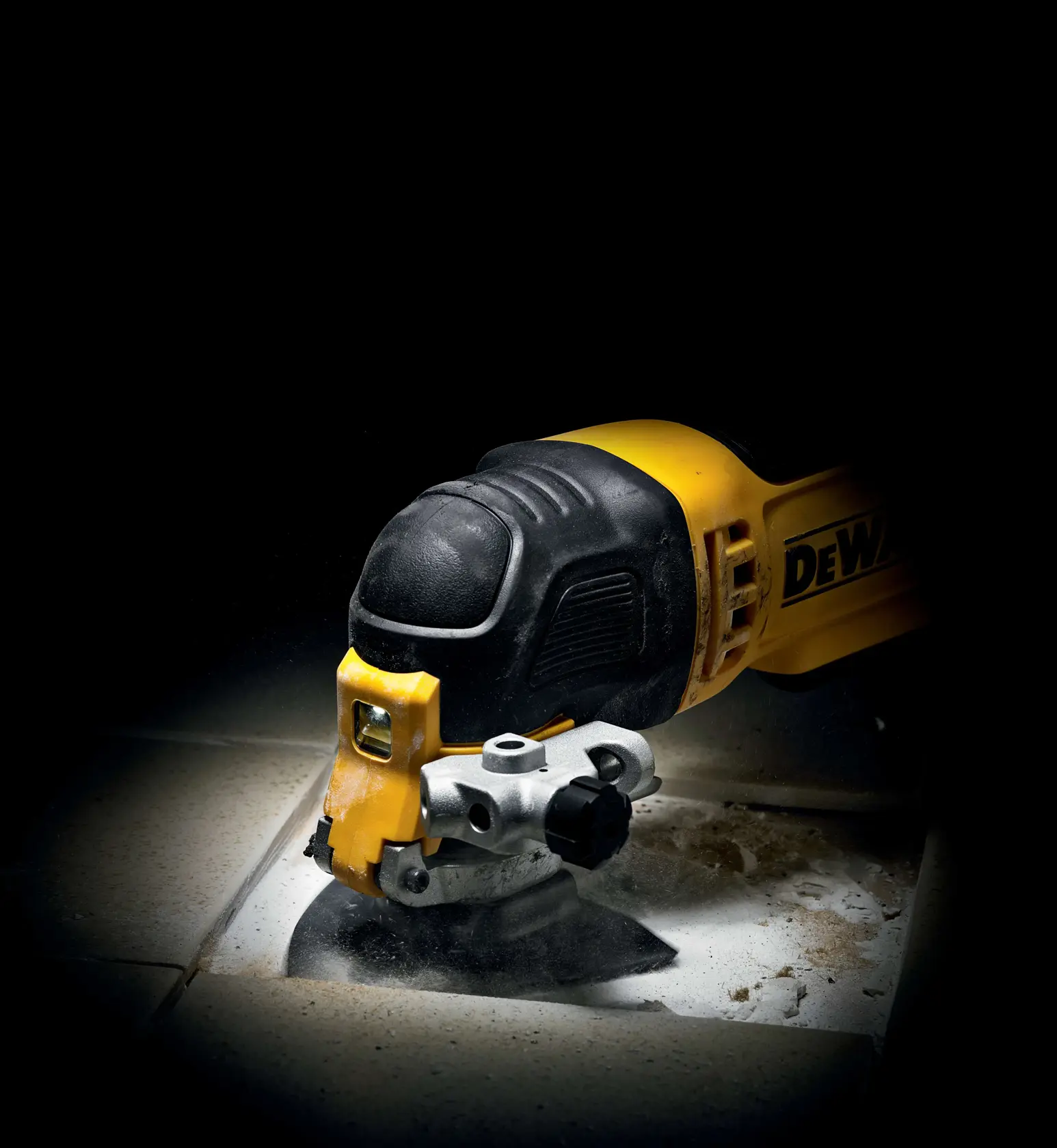 DEWALT-Multitool schneidet Fliese, Staub und Schmutz entstehen auf der Oberfläche.