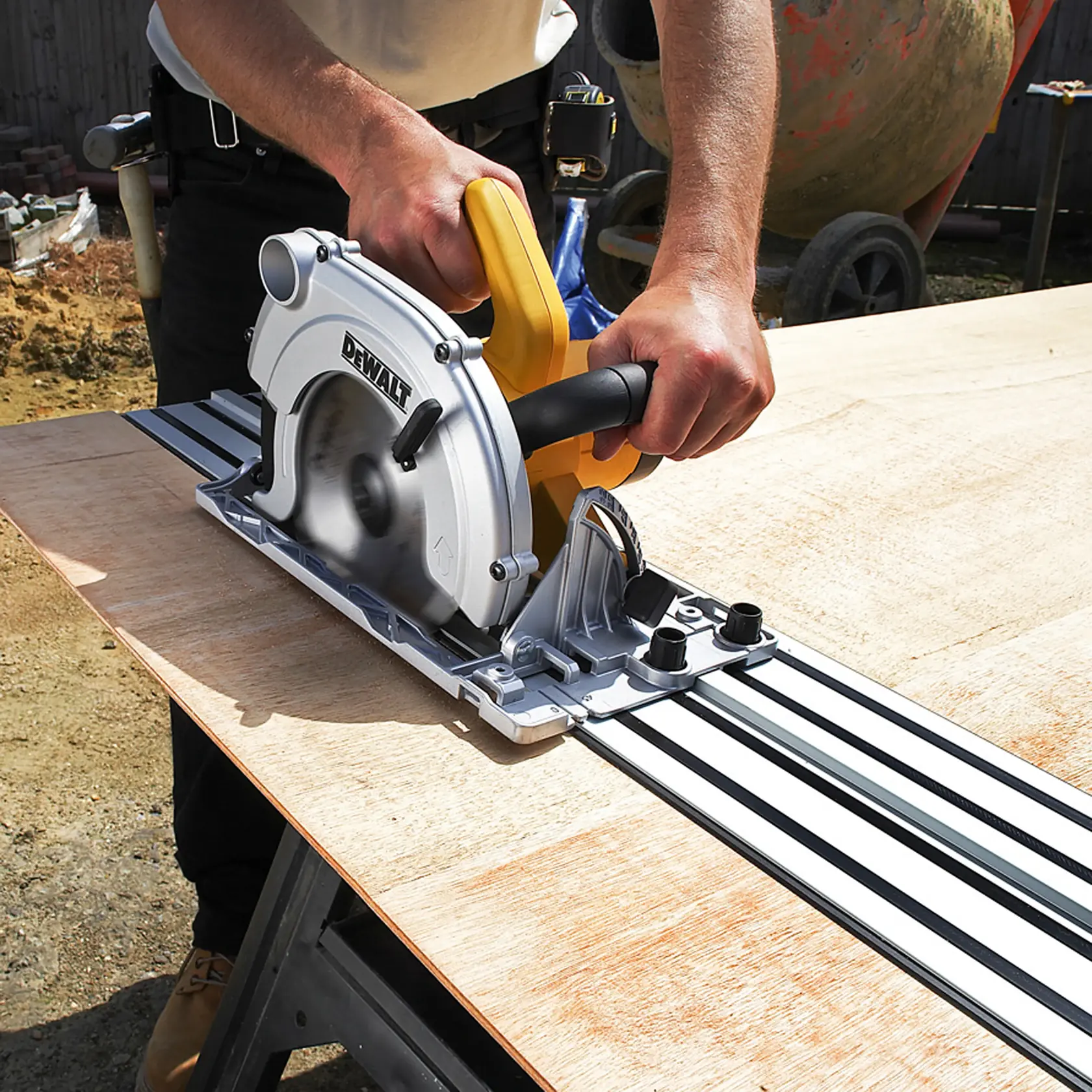 Persona corta una tabla de madera con una sierra circular DEWALT y guía deslizante al aire libre.