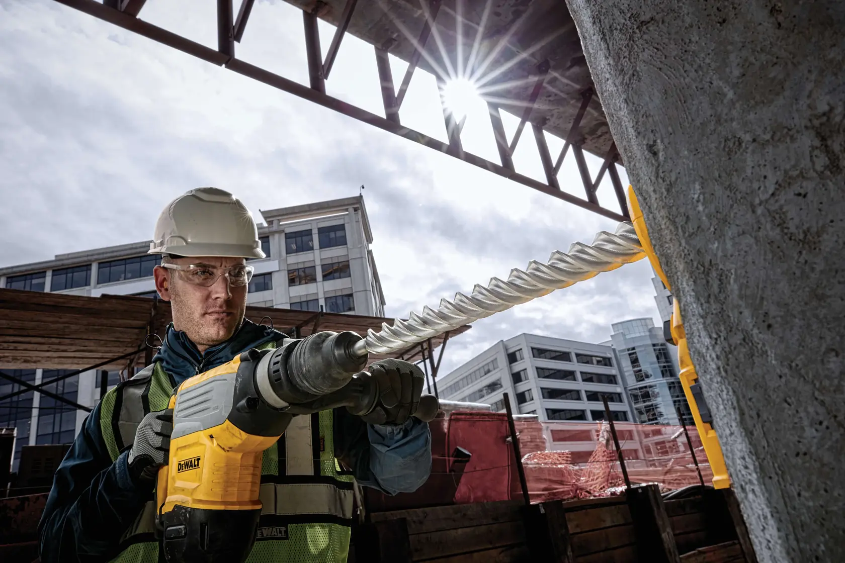 Trabajador usa martillo rotativo DEWALT con DT60845 en concreto en obra.