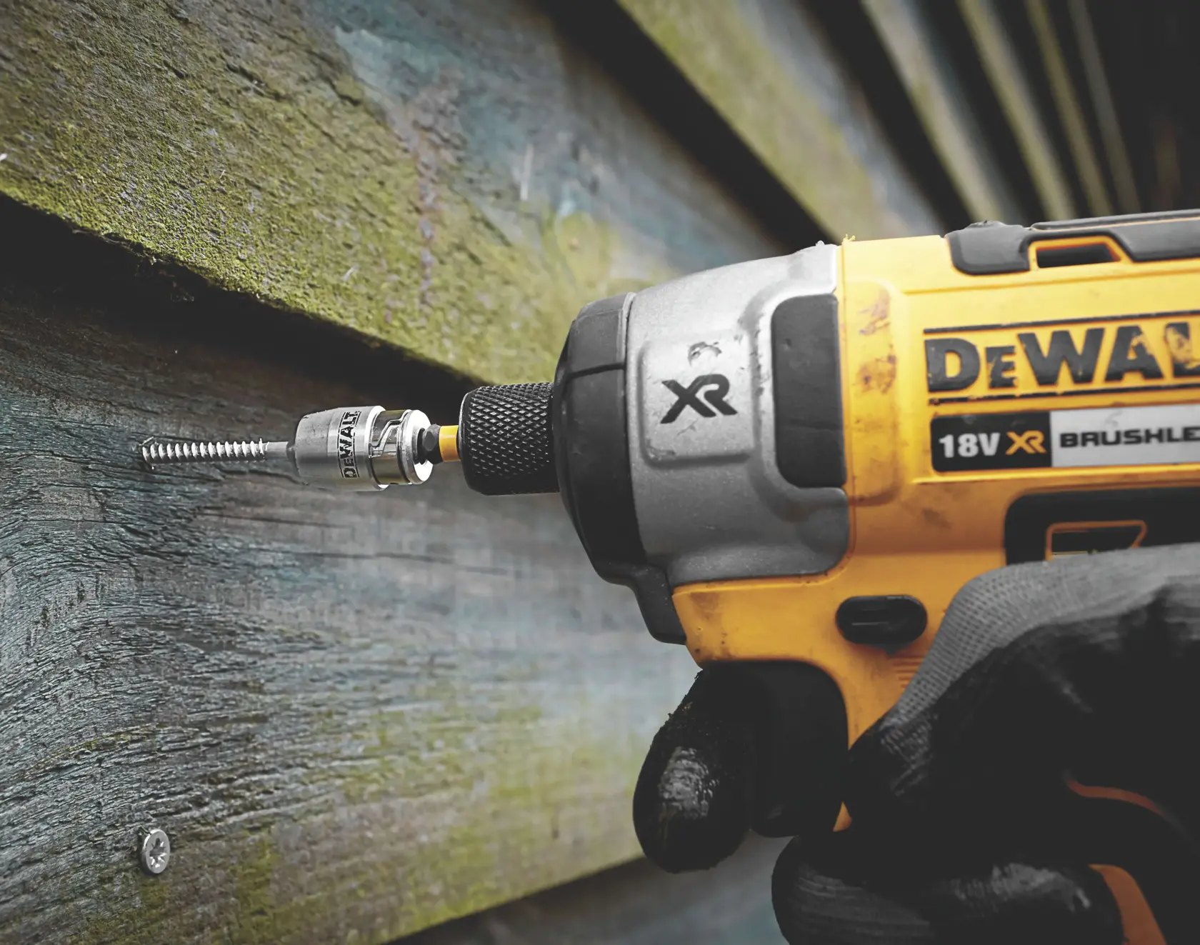Destornillador de impacto DEWALT atornilla en revestimiento de madera exterior.