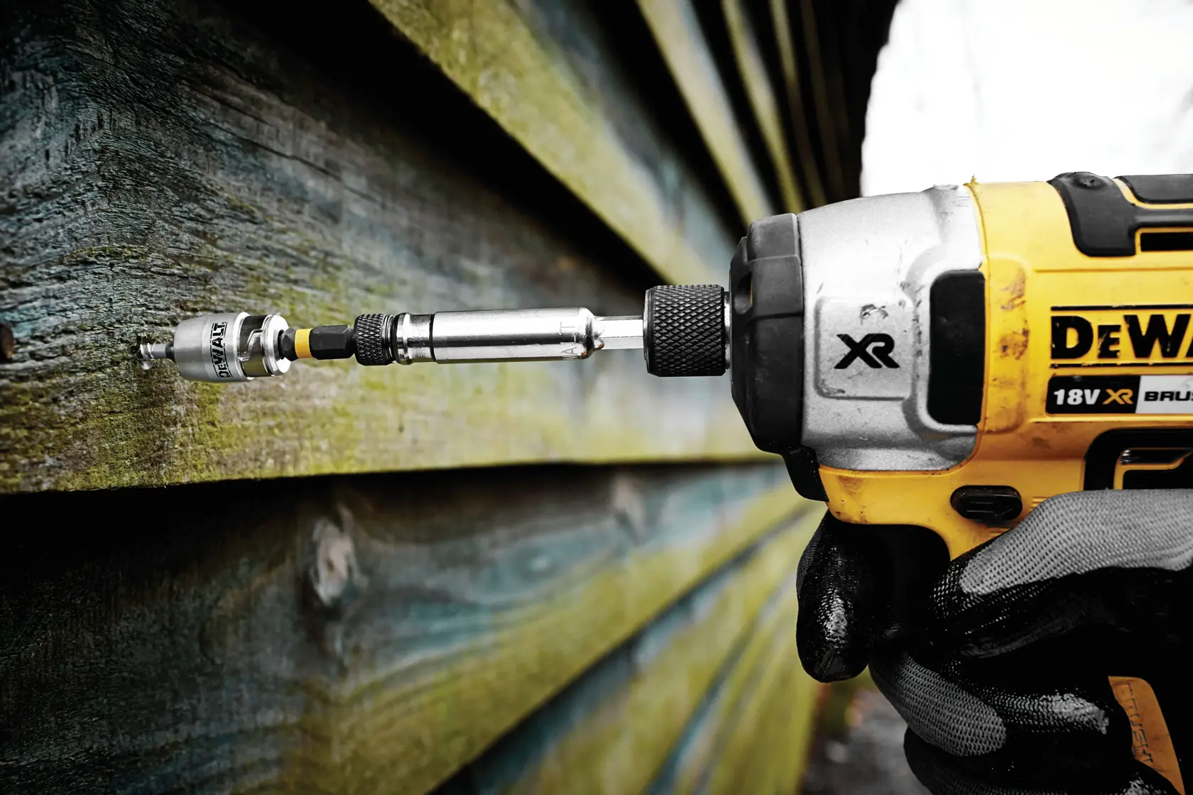 Herramienta DEWALT atornilla en revestimiento exterior de madera.