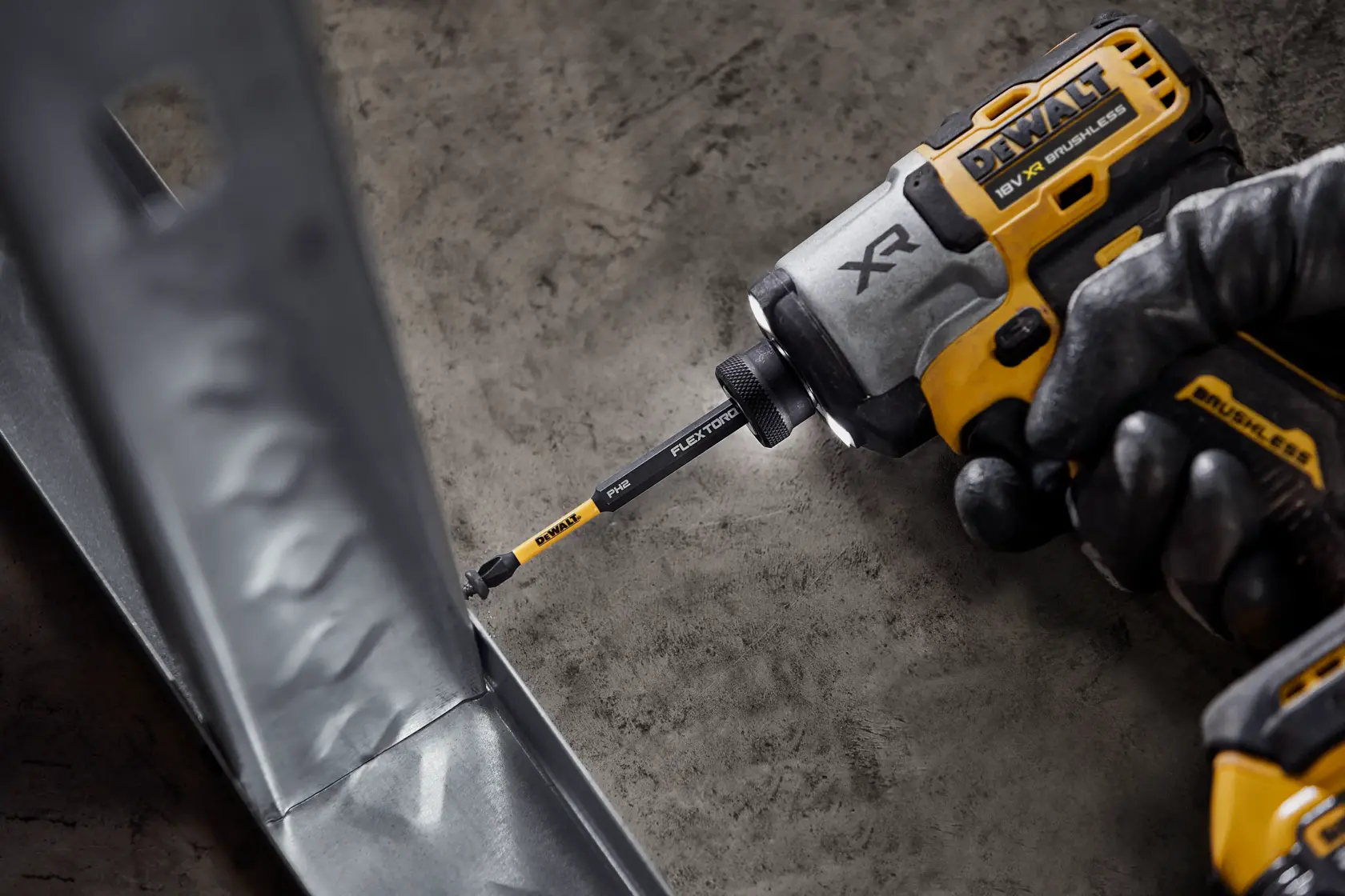 Destornillador DEWALT con punta FlexTorq atornillando en un marco metálico.
