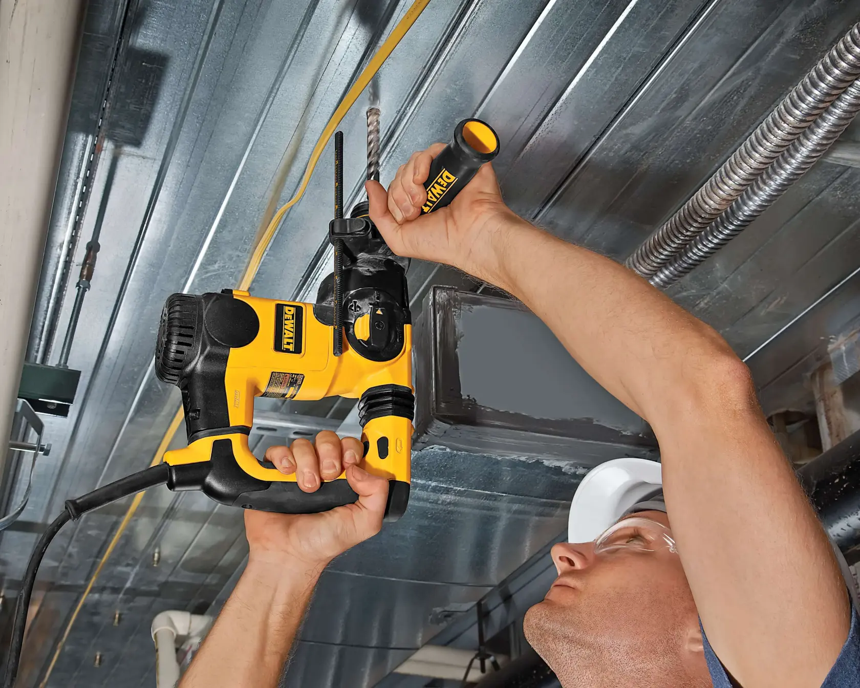 Persona usando taladro DEWALT en un techo metálico, mostrando la herramienta en acción.