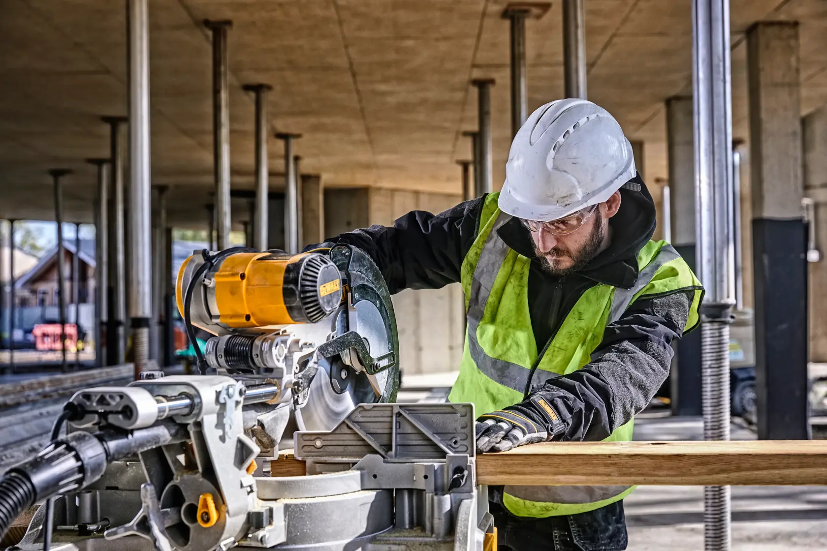 DEWALT DWS780, DWS780KIT Säge im Einsatz auf Baustelle. Arbeiter mit Schutzkleidung. Kategorie Fotografie.