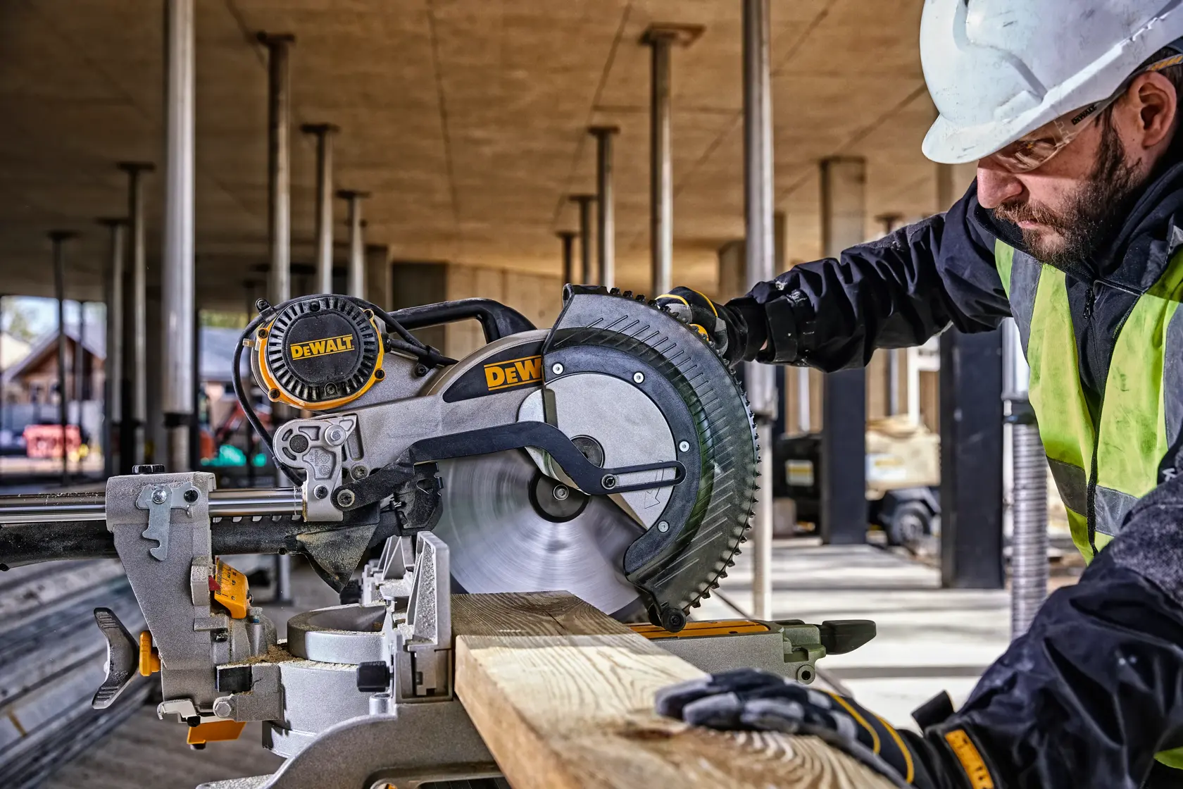DEWALT DWS780, DWS780KIT Säge auf Baustelle, Arbeiter mit Helm und Weste. Kategorie Fotografie.