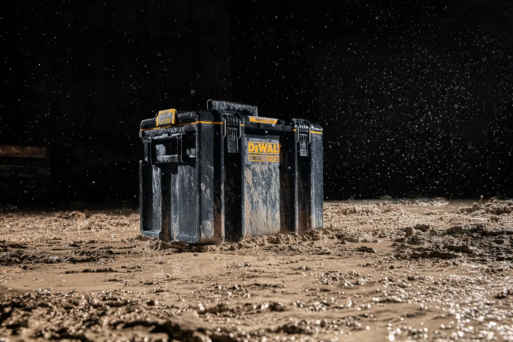 DEWALT DWST83342-1 Werkzeugkasten im Schlamm mit Wasser, betont die Widerstandsfähigkeit.